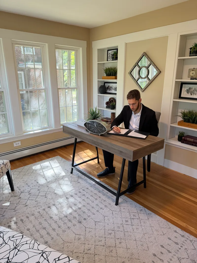 Jared writing in a leather folder at a desk